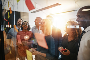 Smiling businesspeople brainstorming together with sticky notes