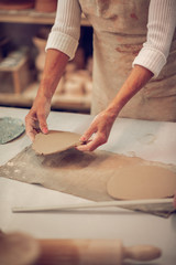 Close up of female hands with a clay piece in them