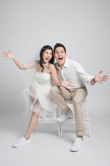 Happy bride and groom sitting on a chair