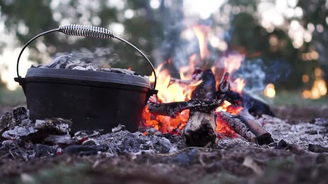 Gorgeous close up shot of a camp oven cooking on an open fire.