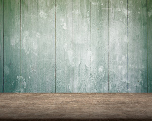 Old brown wooden table with green mottled wood wall background, copy space.