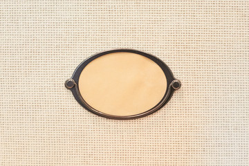 Fototapeta premium Wicker box with label under the inscription, copy space. Wall with a window for writing. Frame for the inscription on the box, close-up.