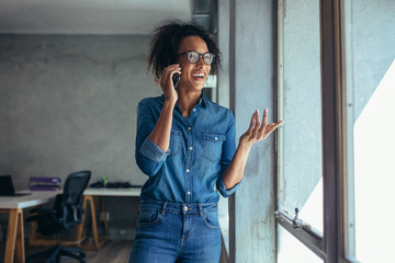 Smiling woman entrepreneur talking over phone