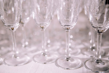 many empty champagne glasses close up. glass goblets on the white table. Empty crystal wineglass. glass goblet on a high leg.