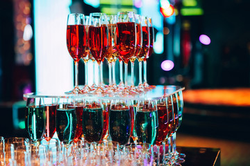 pyramid of champagne glasses. Many glasses of champagne on the bar. bubbles of champagne in a glass. colored champagne.