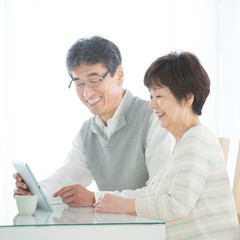 タブレットPCを見るシニア夫婦 © ohayou!