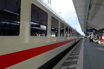 Obraz premium Zug hält im Bahnhof und Fahrgäste steigen ein - Stockfoto