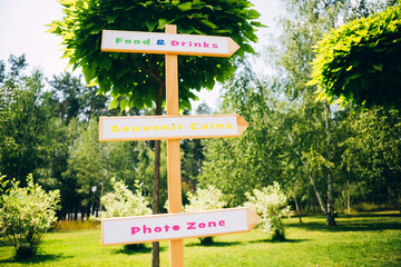 wooden signpost in the park. food and drink. party in the park. wooden arrow.