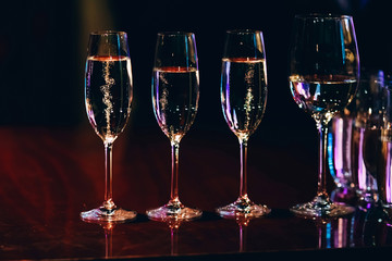 full glass of champagne in a nightclub. Many glasses of champagne on the bar. bubbles of champagne in a glass.