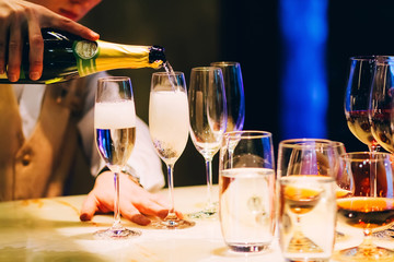the bartender pours champagne. waiter pouring champagne at a party.