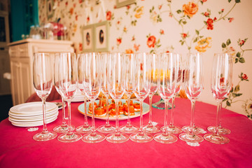 many empty champagne glasses close up. glass goblets on the pink table. Empty crystal wine glass. glass goblet on a high leg.