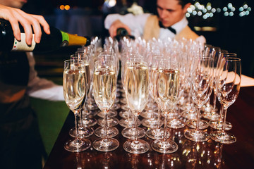 the bartender pours champagne. waiter pouring champagne at a party.