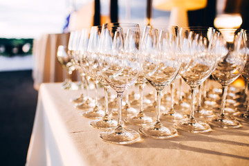 many empty champagne glasses close up. glass goblets on the white table. Empty crystal wine glass. glass goblet on a high leg.