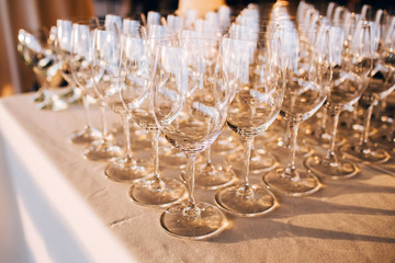 many empty champagne glasses close up. glass goblets on the white table. Empty crystal wine glass. glass goblet on a high leg.