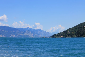 Summer landscape on lake Garda Italy with turquoise water and green mountains on the banks