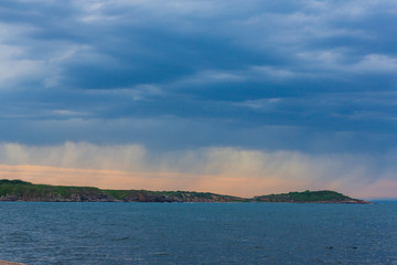 a marine landscape in the blue hour and a storm on the horizon. sea scenery and dramatic clouds. setting sun rising on the horizon.