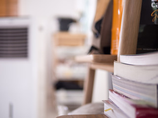 Stacks of books in living room with blurred background.