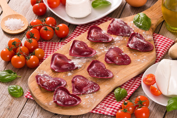 Red heart ravioli with tomato, mozzarella and basil. 