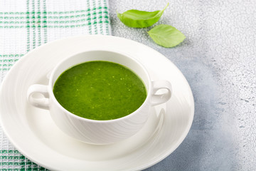 The concept of a healthy, vegetarian or dietary food: cream spinach soup, with pine nuts and basil. With slices of vegetarian carrot bread. On a light background