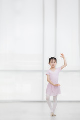 Fototapeta na wymiar Pink dressed Asian girl in a ballet pose..