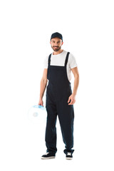 happy delivery man holding bottle of water and looking at camera isolated on white