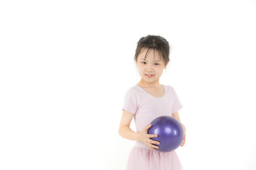 Asian girl in pink dress is holding ball..