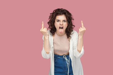Portrait of angry screaming brunette young woman with curly hairstyle in casual style standing and...