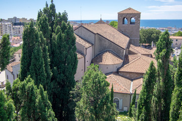 Obraz premium Trieste Cathedral next the Castello di San Giusto during touristic season.