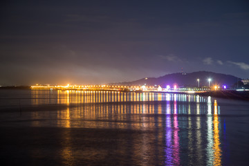 Obraz premium The sea at night has a light on the horizon.