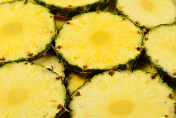 Pineapple juicy yellow slices background. Top view.