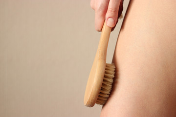 girl uses a natural bristle massage brush at home. Cellulite prevention, skin care