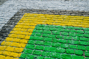 Close-up roapd aving slabs by mosaic construction. Yellow, green, black, white paving cobbles.