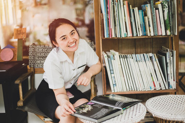 university uniform girl teen reading a book  looking camera happy smile vintage color tone