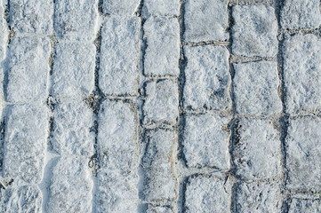 Close-up road aving slabs by mosaic construction. White paving cobbles.