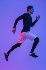 Full length portrait of a fit sportsman running isolated