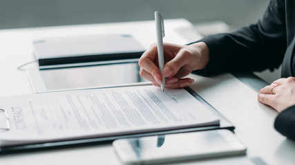 Modern business investment. Corporate relationship. Closeup of female hand signing contract.