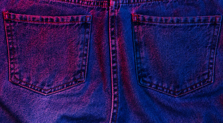 Retro futurism background. Texture of crumpled pocket jeans with red-blue neon light. 80s