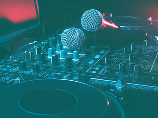 Night club, nightlife concept. Disco. Two microphone on DJ remote. Neon red blue light
