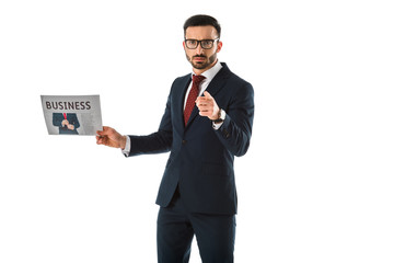 serious businessman holding businessman holding newspaper and pointing with finger at camera isolated on white