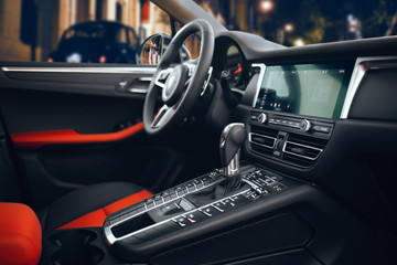 Expensive and luxury car interior with steering wheel, multimedia and gearbox handle. Modern SUV interior 
