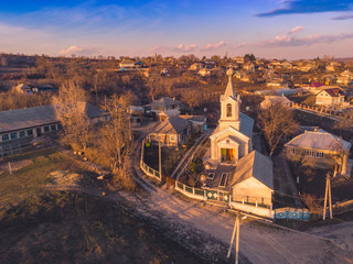 Fototapeta na wymiar the beautiful church at sunset in a small village in Moldova. Aerial view