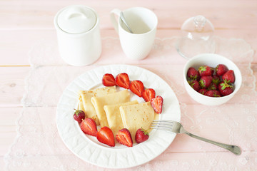 pancakes with strawberries on the table on a white background