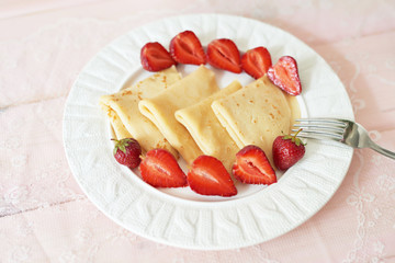 pancakes with strawberries on the table on a white background