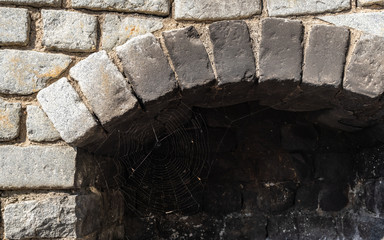 Stone oven.  Close up of Traditional stone oven. Grey stone texture. Spider web close up.