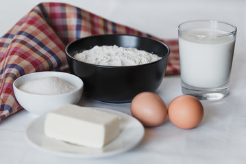 Ingredients for pancake. Flour, sugar, butter, eggs and milk on the table.
