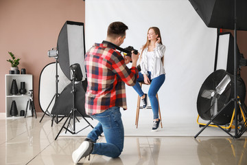 Young male photographer working with model in studio