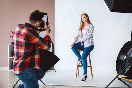 Young male photographer working with model in studio