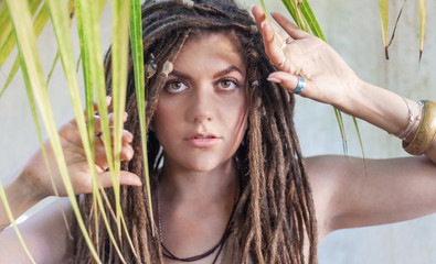 Fototapeta premium young beautiful woman with tropical green leaves at background