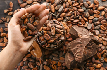 Female hand with cocoa beans and chocolate