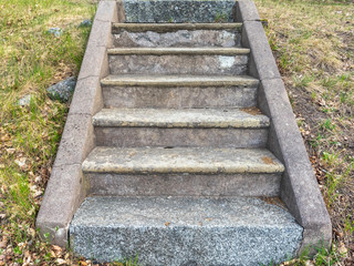 Granite stone stairs. Old vintage granite texture stairway. Grey Grunge blocks stairs with Green...